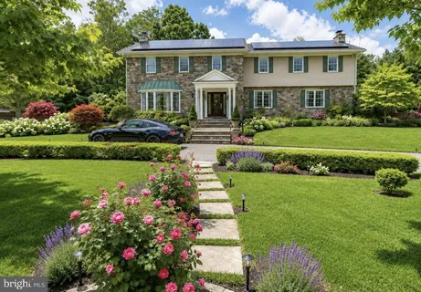 a front view of a house with a garden and trees