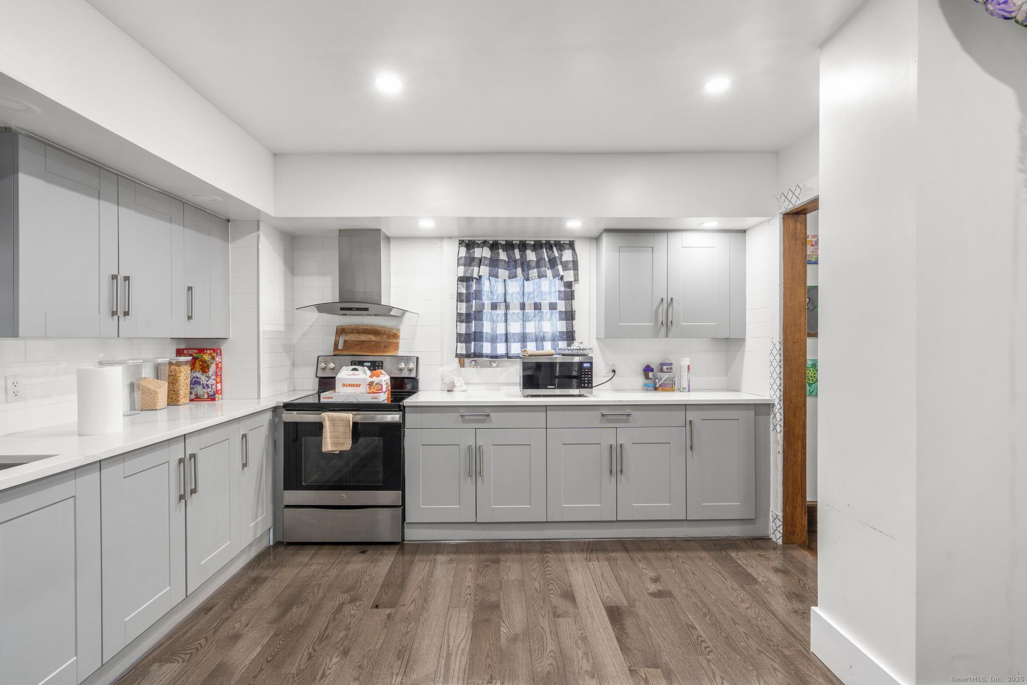699 Forest Road West Haven, CT 06516 - Photo 6 of 28 a kitchen with granite countertop white cabinets and white appliances