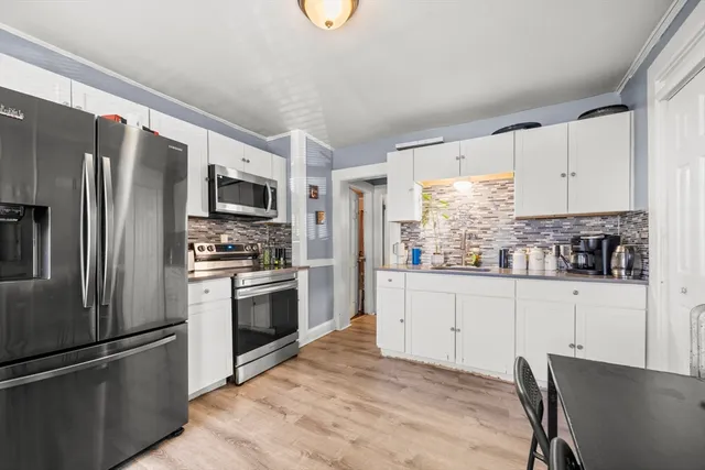 a kitchen with granite countertop a refrigerator stove and microwave