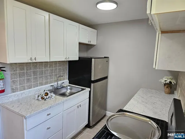 a kitchen with a sink refrigerator and cabinets