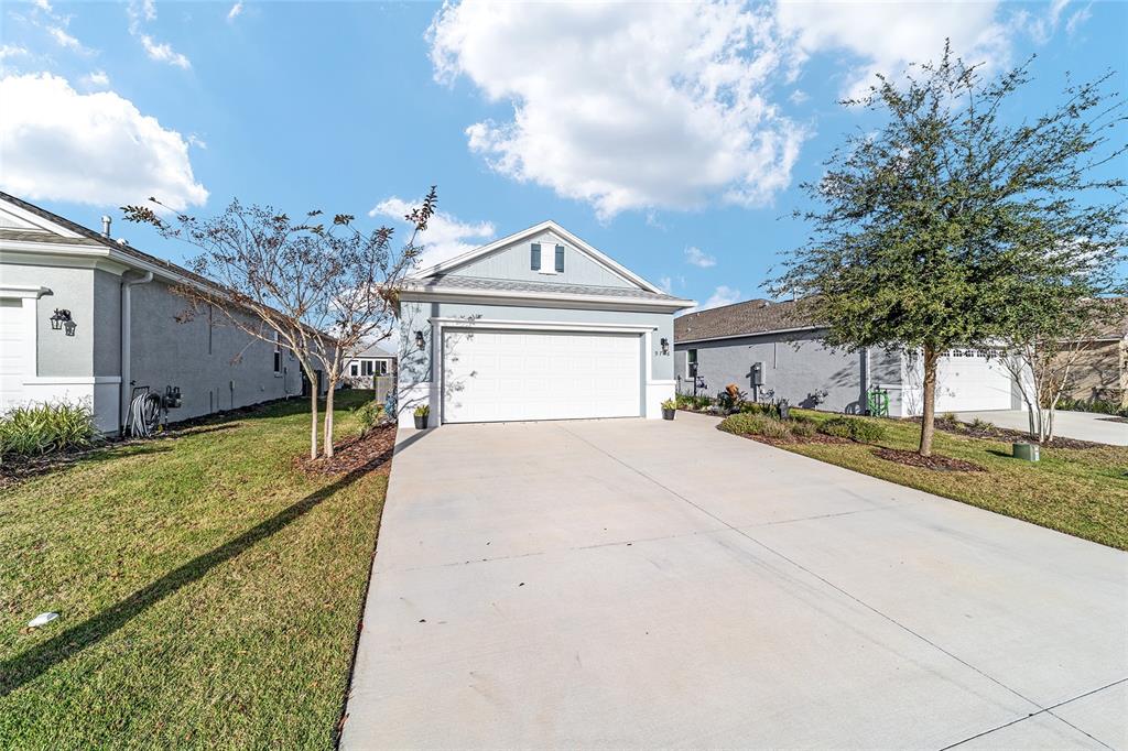 9776 Southwest 100th Avenue Ocala, FL 34481 - Photo 4 of 52 a front view of a house with a yard and garage