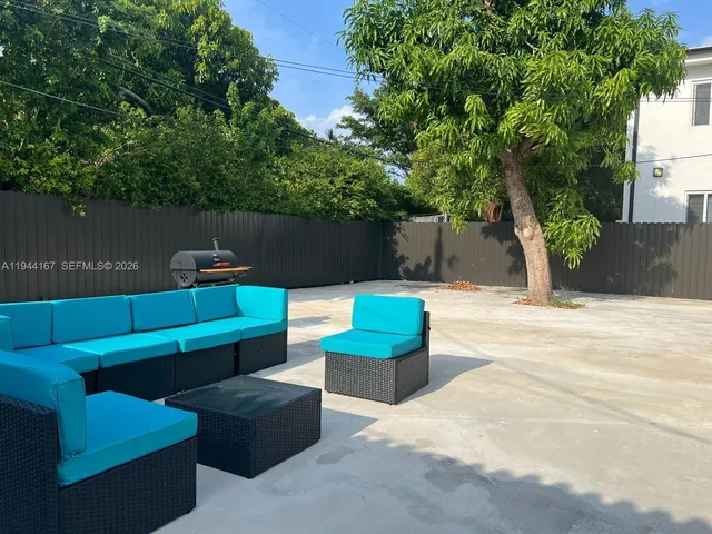 a roof deck with couches and potted plants