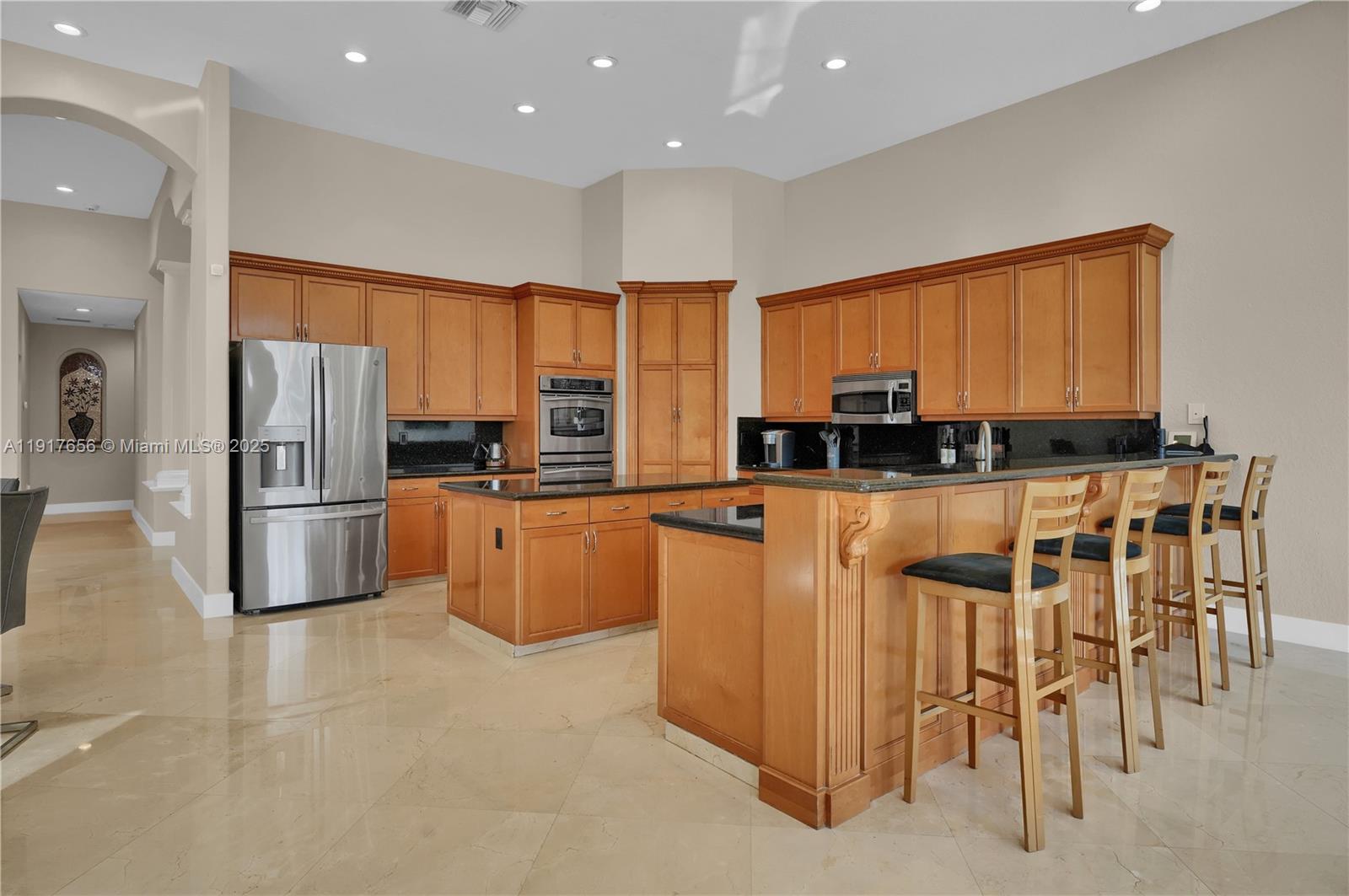 14896 Southwest 38th Street Davie, FL 33331 - Photo 22 of 60 a kitchen with stainless steel appliances a refrigerator a stove a sink a dining table and chairs