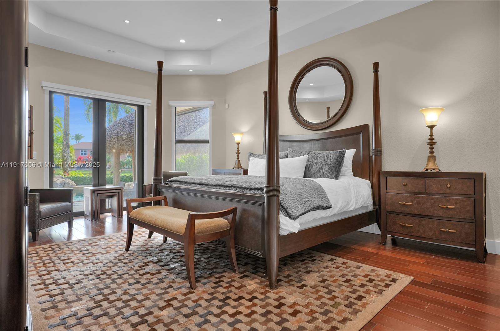 14896 Southwest 38th Street Davie, FL 33331 - Photo 35 of 60 a bedroom with a bed a mirror and a table with wooden floor