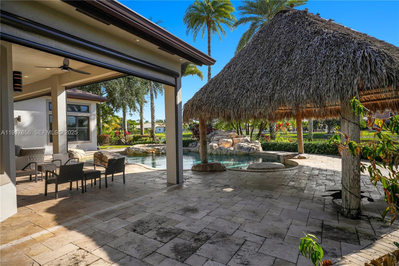 14896 Southwest 38th Street Davie, FL 33331 - Photo 53 of 60 a view of a patio with table and chairs under an umbrella next to a yard