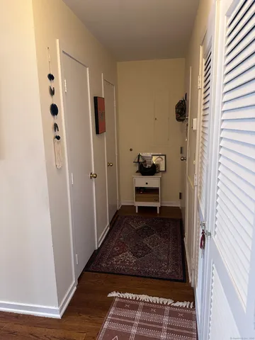 a view of utility room with closet and wooden floor