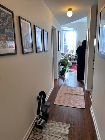 a view of a hallway with furniture and a window