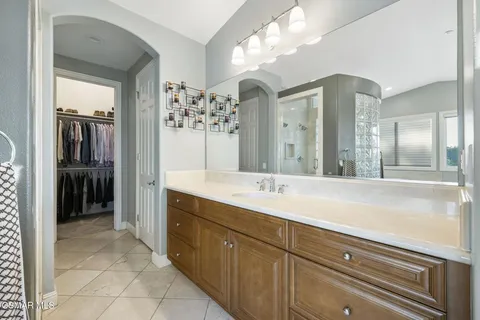 a spacious bathroom with a granite countertop sink a mirror and a shower