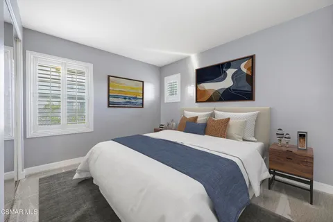 a bedroom with bed and wall painting with wooden floor