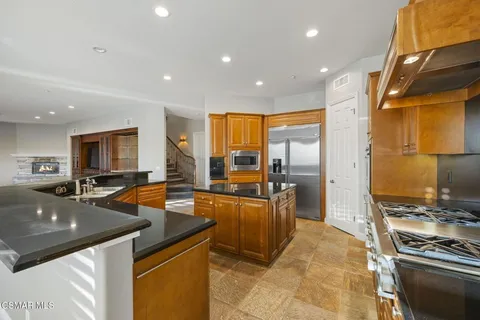 a kitchen with sink refrigerator and stove top oven