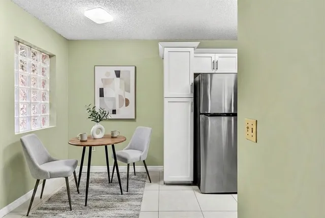 a dining room with stainless steel appliances a refrigerator and a table