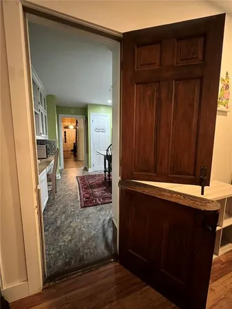 a large living room with stainless steel appliances kitchen island granite countertop a large window and a couch