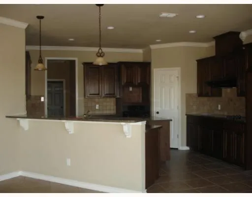 a kitchen with a refrigerator and a black cabinet
