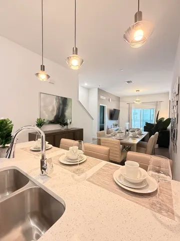 a kitchen with kitchen island a sink a counter and chairs