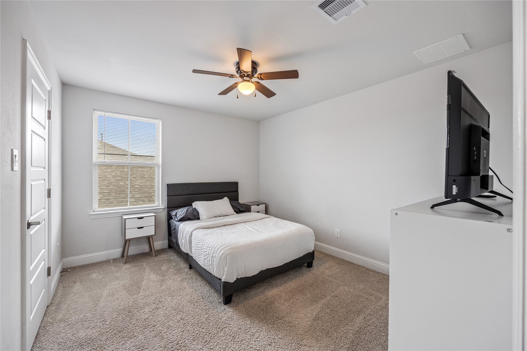 32906 Ruthie Dean Drive Brookshire, TX 77423 - Photo 16 of 23 a bedroom with a bed and a flat tv screen on the dresser