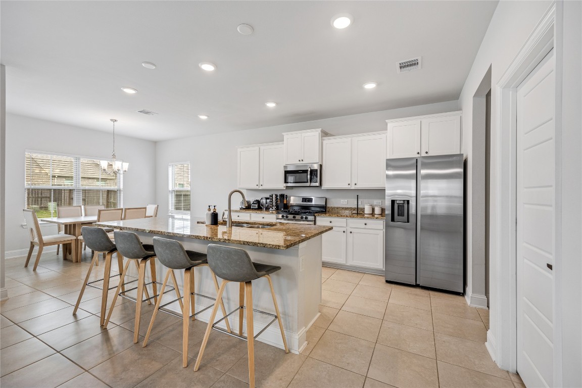 32906 Ruthie Dean Drive Brookshire, TX 77423 - Photo 7 of 23 a kitchen with stainless steel appliances granite countertop a table chairs sink and cabinets