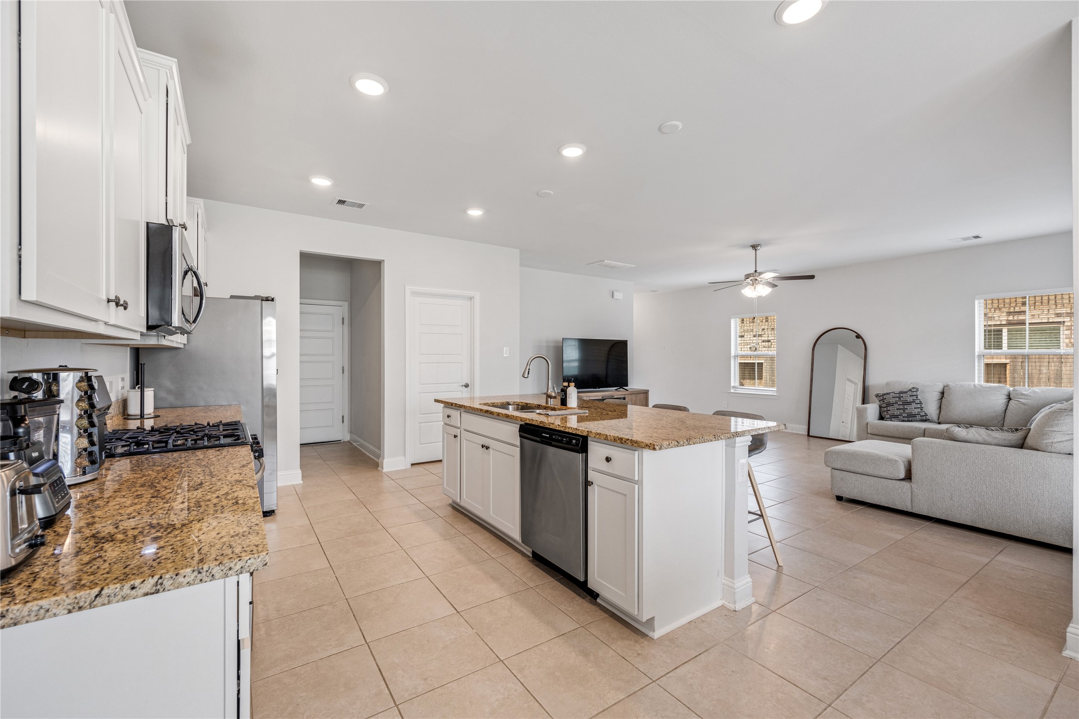 32906 Ruthie Dean Drive Brookshire, TX 77423 - Photo 8 of 23 a open kitchen with stainless steel appliances granite countertop a stove top oven a sink and a refrigerator