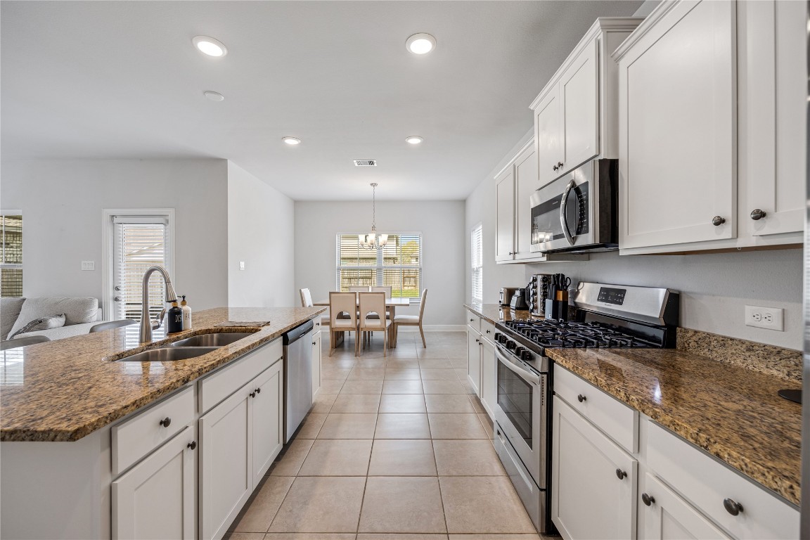 32906 Ruthie Dean Drive Brookshire, TX 77423 - Photo 9 of 23 a large kitchen with stainless steel appliances granite countertop a sink stove and cabinets