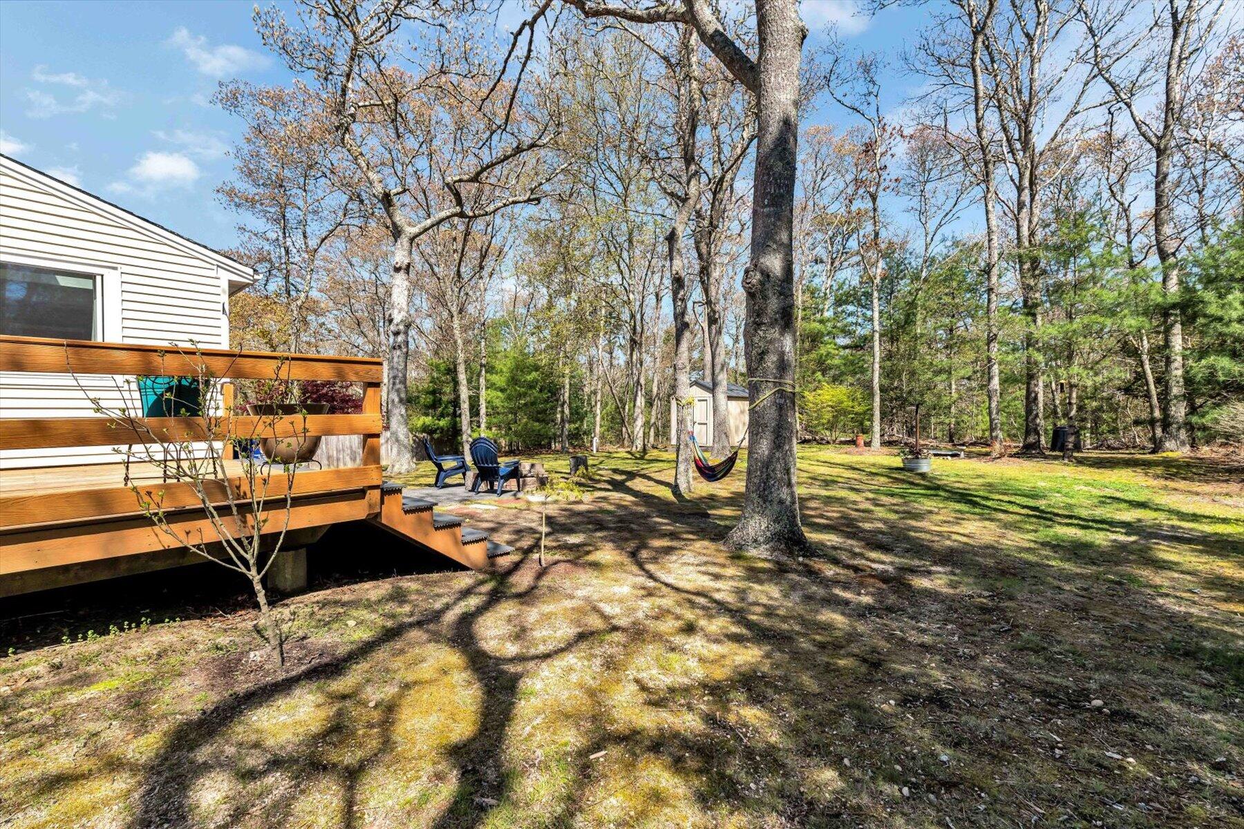 79 Clay Pond Road Monument Beach, MA 02532 - Photo 32 of 46 a backyard of a house with barbeque oven table and chairs