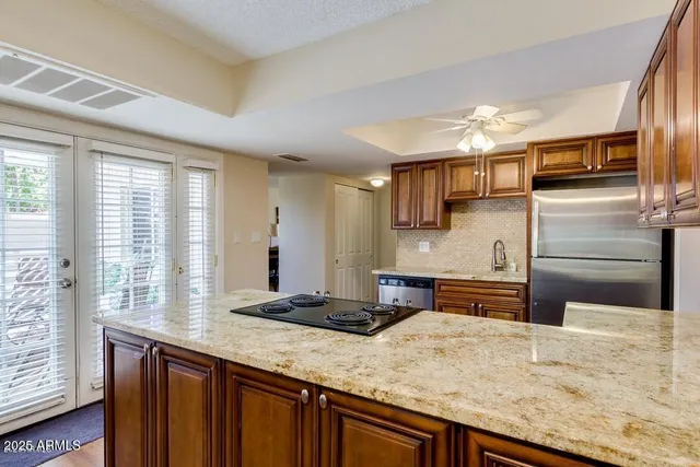a kitchen with stainless steel appliances kitchen island granite countertop a sink and cabinets