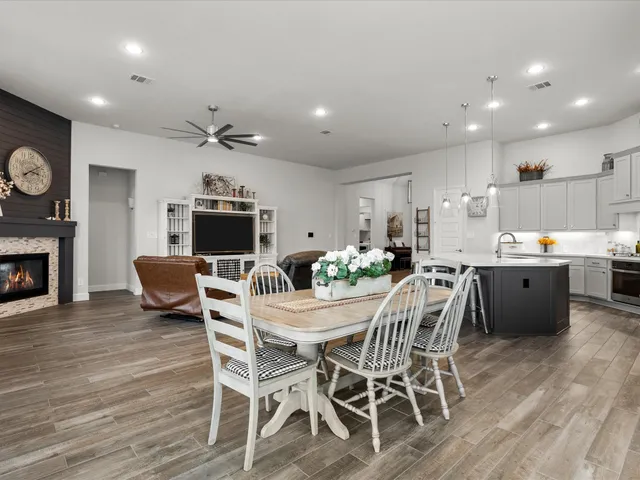 a view of a dining room with furniture a fireplace and wooden floor