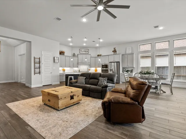 a living room with furniture and a wooden floor