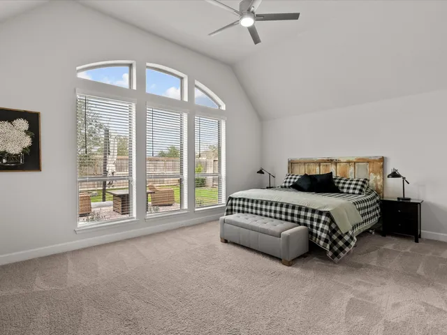 a spacious bedroom with a bed and a large window