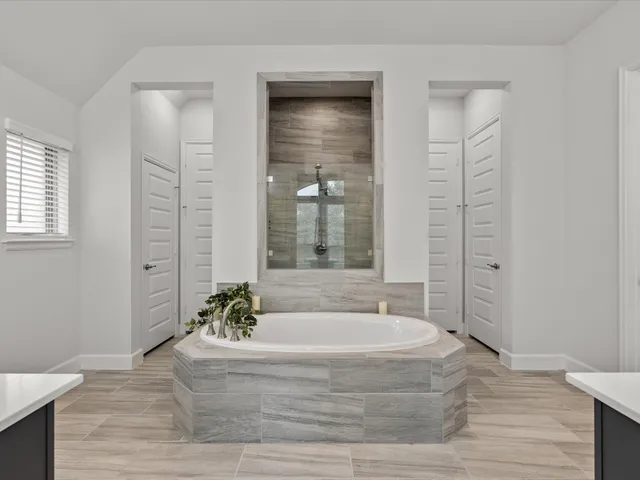 a spacious bathroom with a bathtub and shower