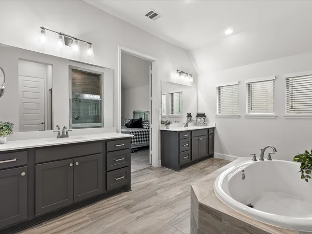 a spacious bathroom with a double vanity sink double mirror and bathtub