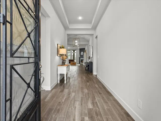 a view of hallway with wooden floor and livingroom