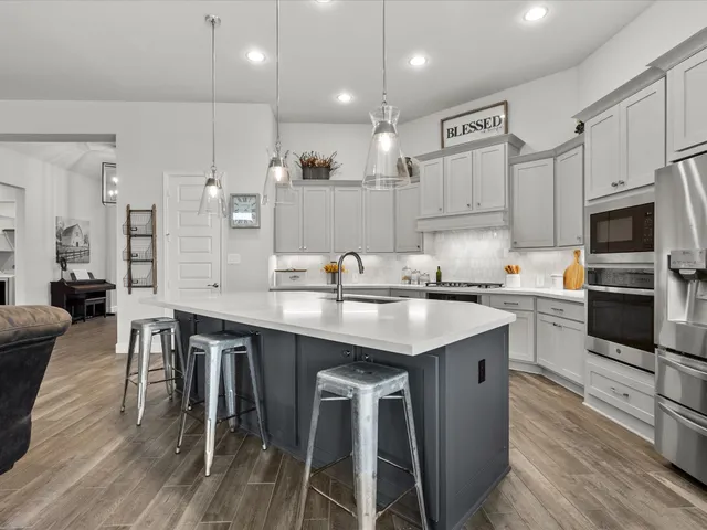 a kitchen with granite countertop a sink appliances cabinets and wooden floor