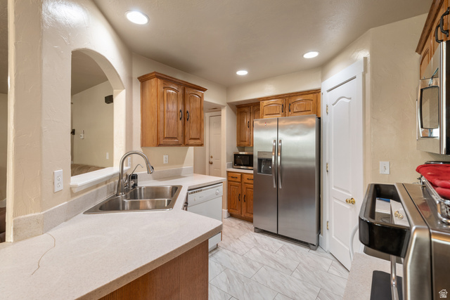 802 Brookside Court Payson, UT 84651 - Photo 15 of 32 Kitchen featuring stainless steel appliances, wood finish cabinets, light countertops, light marble finish flooring, and recessed lighting