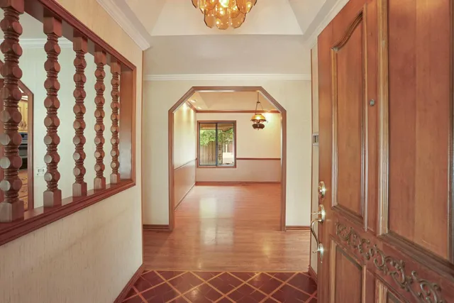 a view of a hallway with wooden floor and entryway