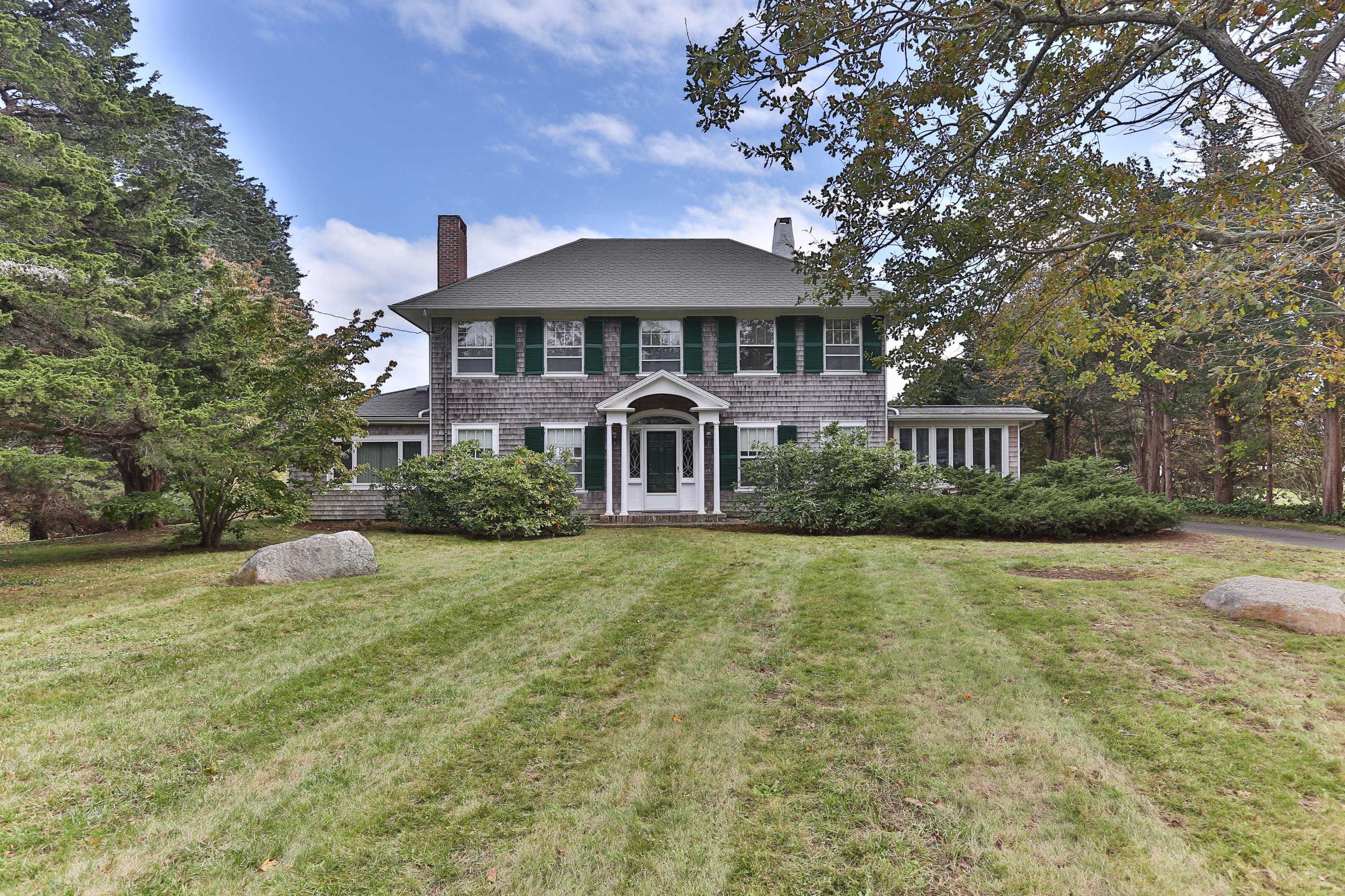 a front view of a house with yard and green space