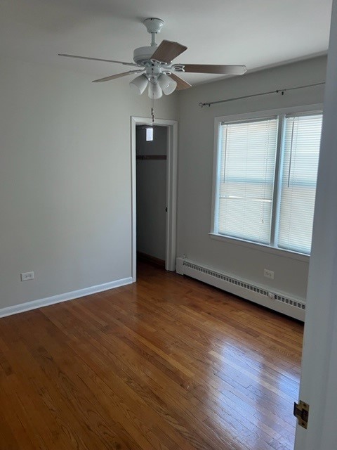 5454 West Windsor Avenue, Unit 2 Chicago, IL 60630 - Photo 3 of 12 an empty room with wooden floor fan and windows