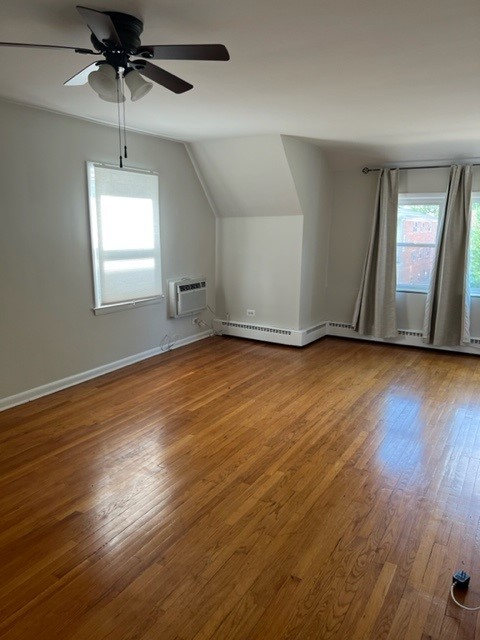 5454 West Windsor Avenue, Unit 2 Chicago, IL 60630 - Photo 4 of 12 a view of an empty room with window and wooden floor