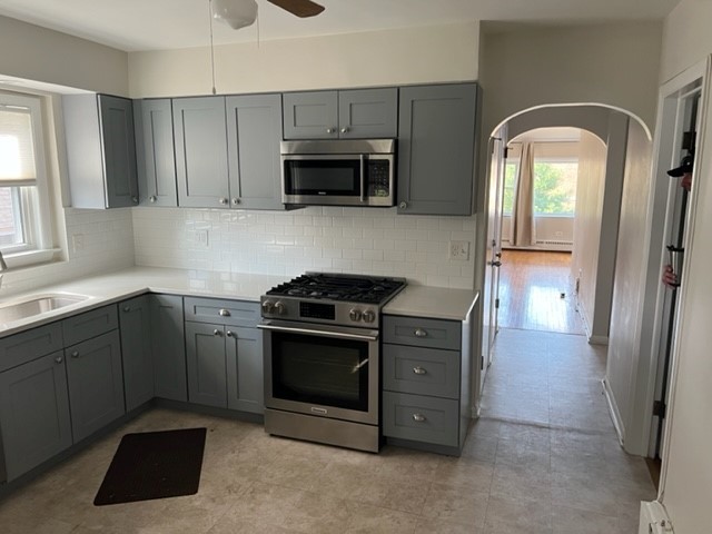 5454 West Windsor Avenue, Unit 2 Chicago, IL 60630 - Photo 9 of 12 a kitchen with stainless steel appliances granite countertop a stove a sink and a refrigerator