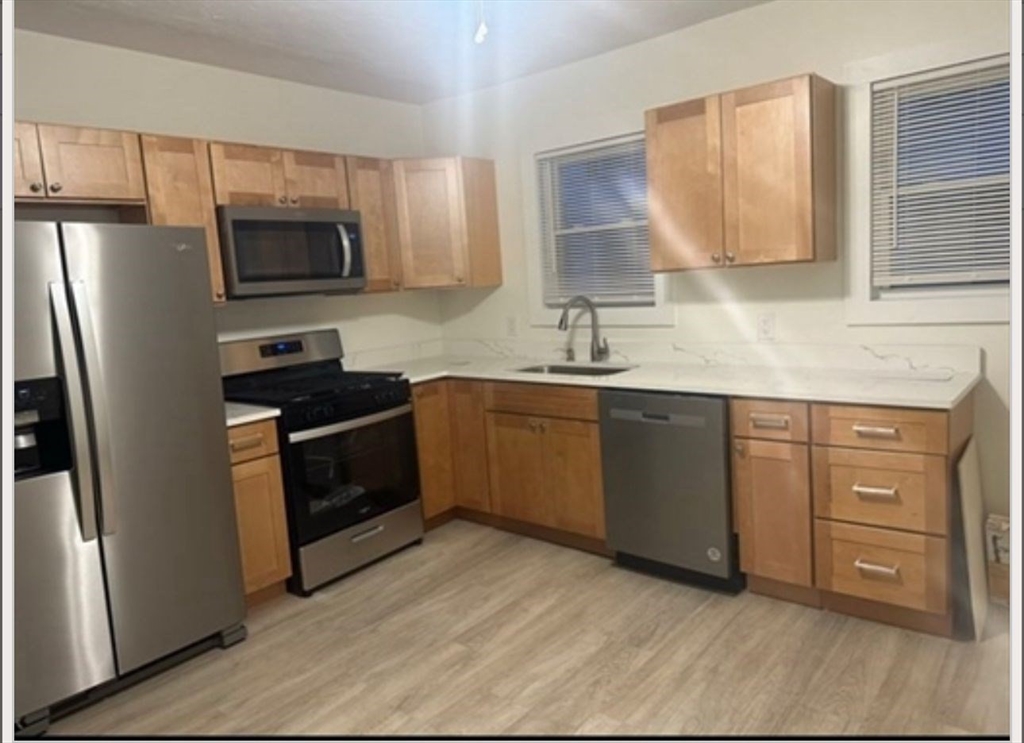 a kitchen with white cabinets stainless steel appliances and sink