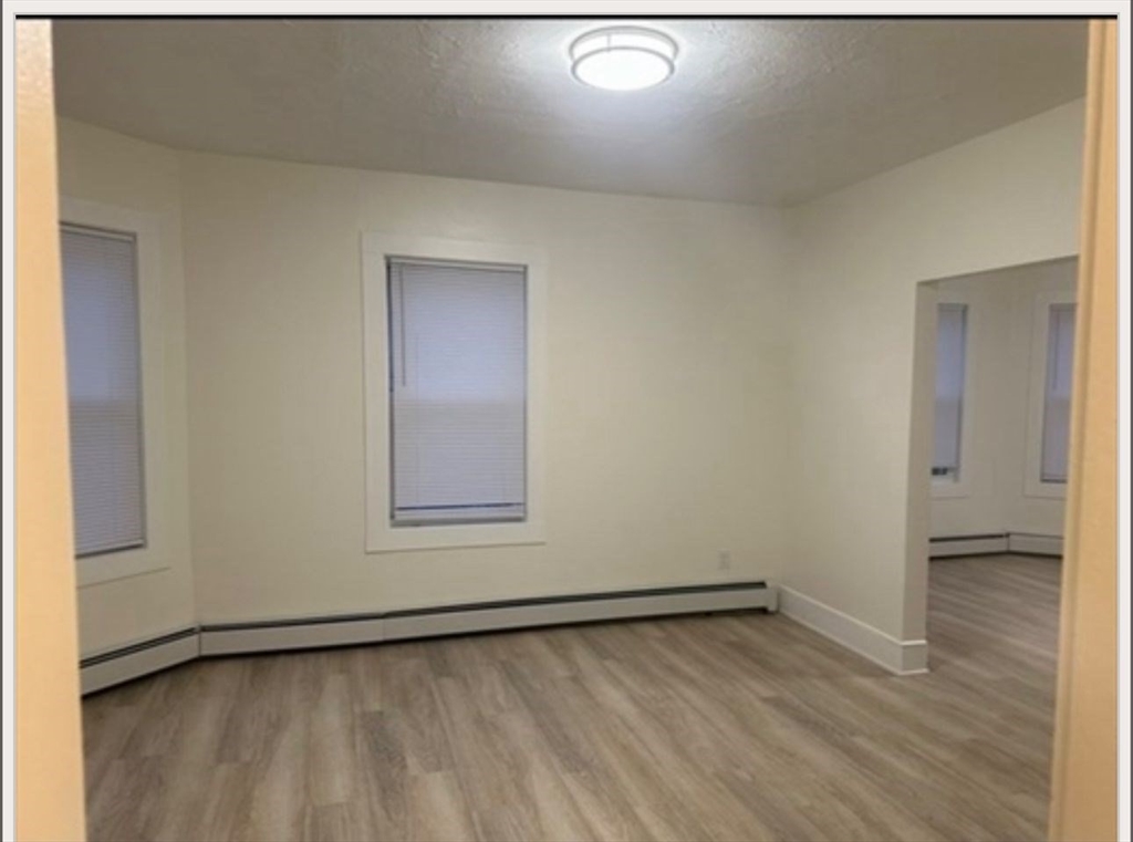 11 High Street, Unit 3 North Attleboro, MA 02760 - Photo 2 of 5 a view of an empty room with wooden floor and a window