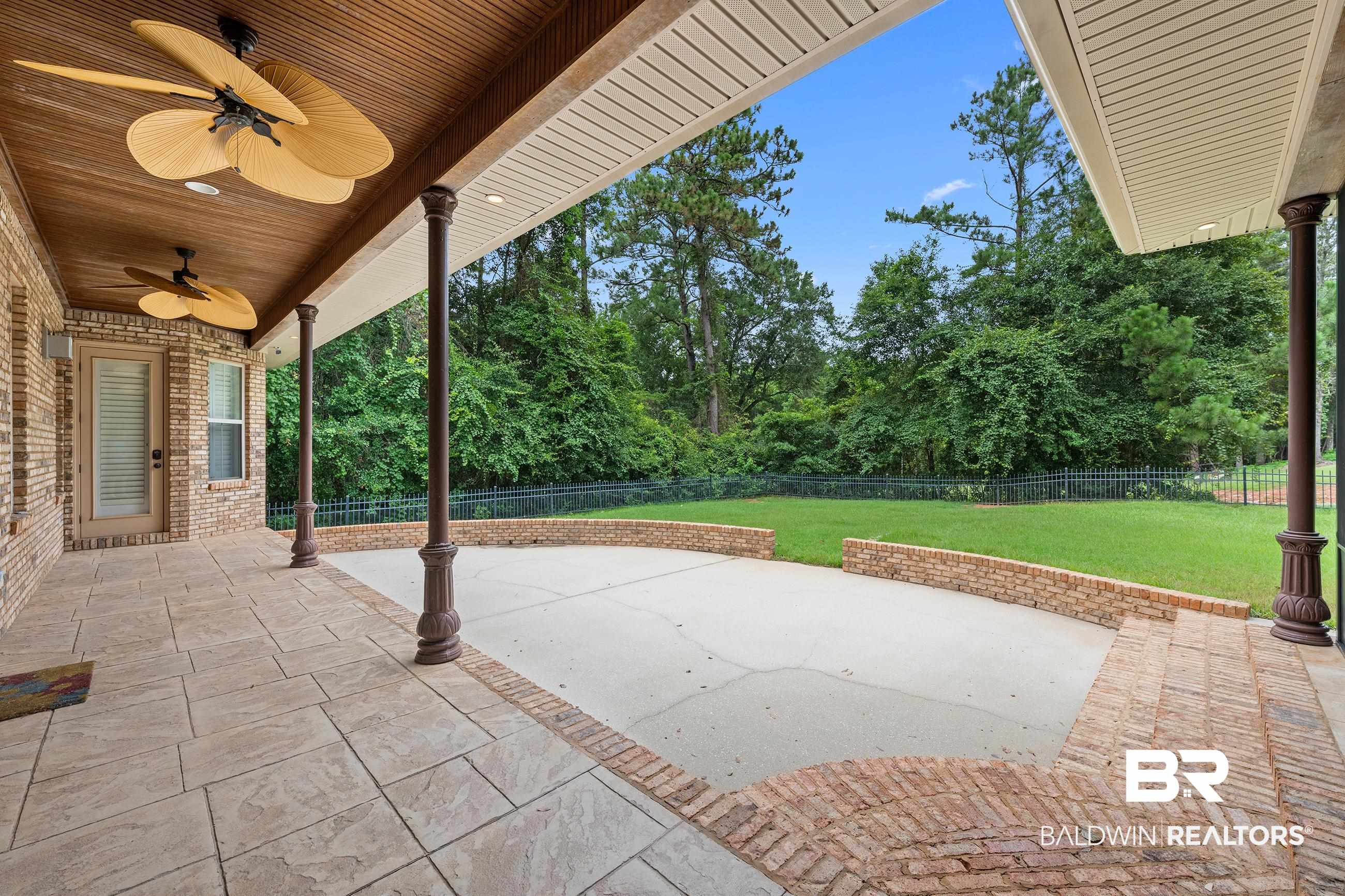 30463 Dolive Ridge Daphne, AL 36527 - Photo 19 of 58 Covered patio featuring a wood-paneled ceiling with two ceiling fans, brick exterior, and tile flooring
