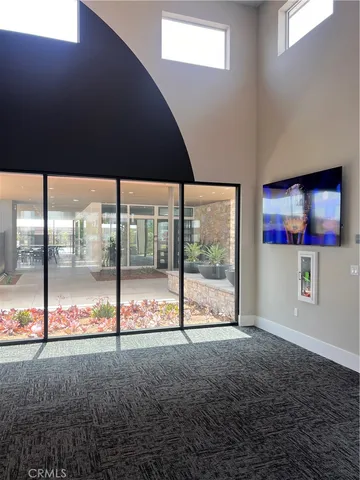 a view of an empty room with wooden floor and windows