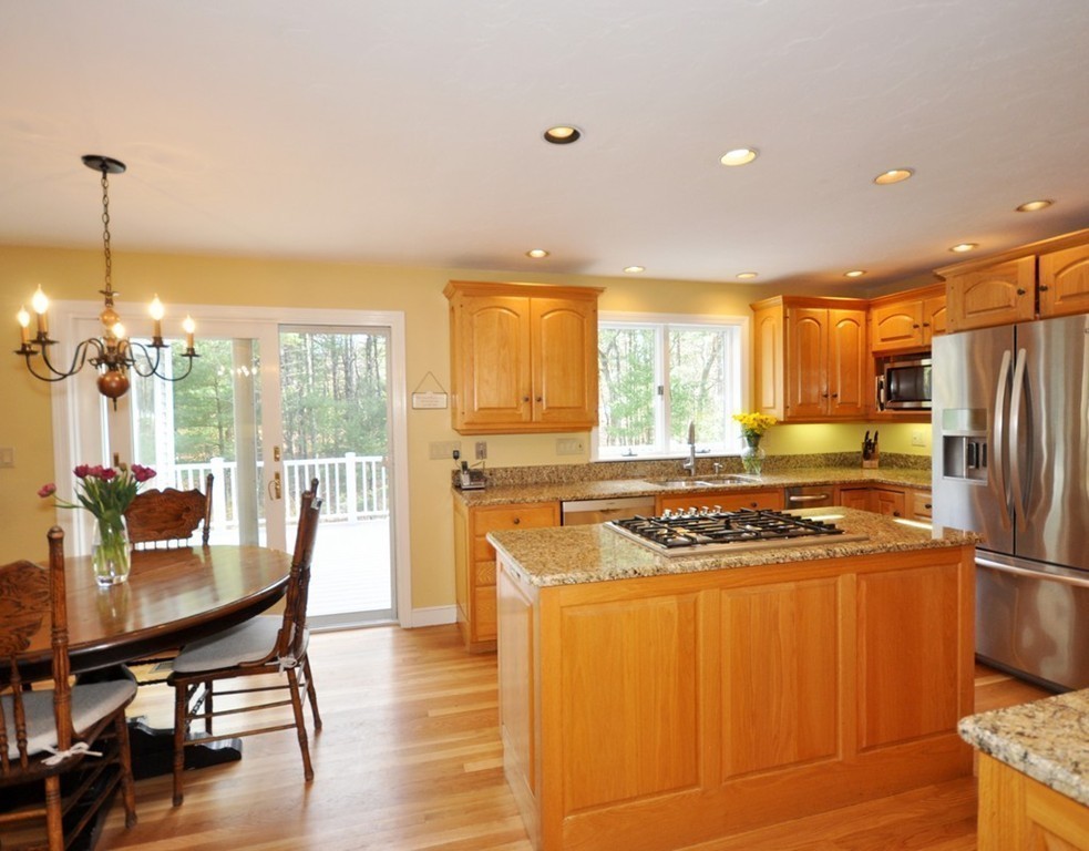 1055 Old Marlboro Road Concord, MA 01742 - Photo 8 of 19 a kitchen with stainless steel appliances granite countertop a stove a refrigerator a kitchen island a dining table and chairs with wooden floor