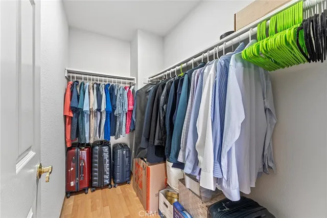 a view of walk in closet with clothes and shoes