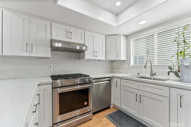 a kitchen with cabinets appliances a sink and a window