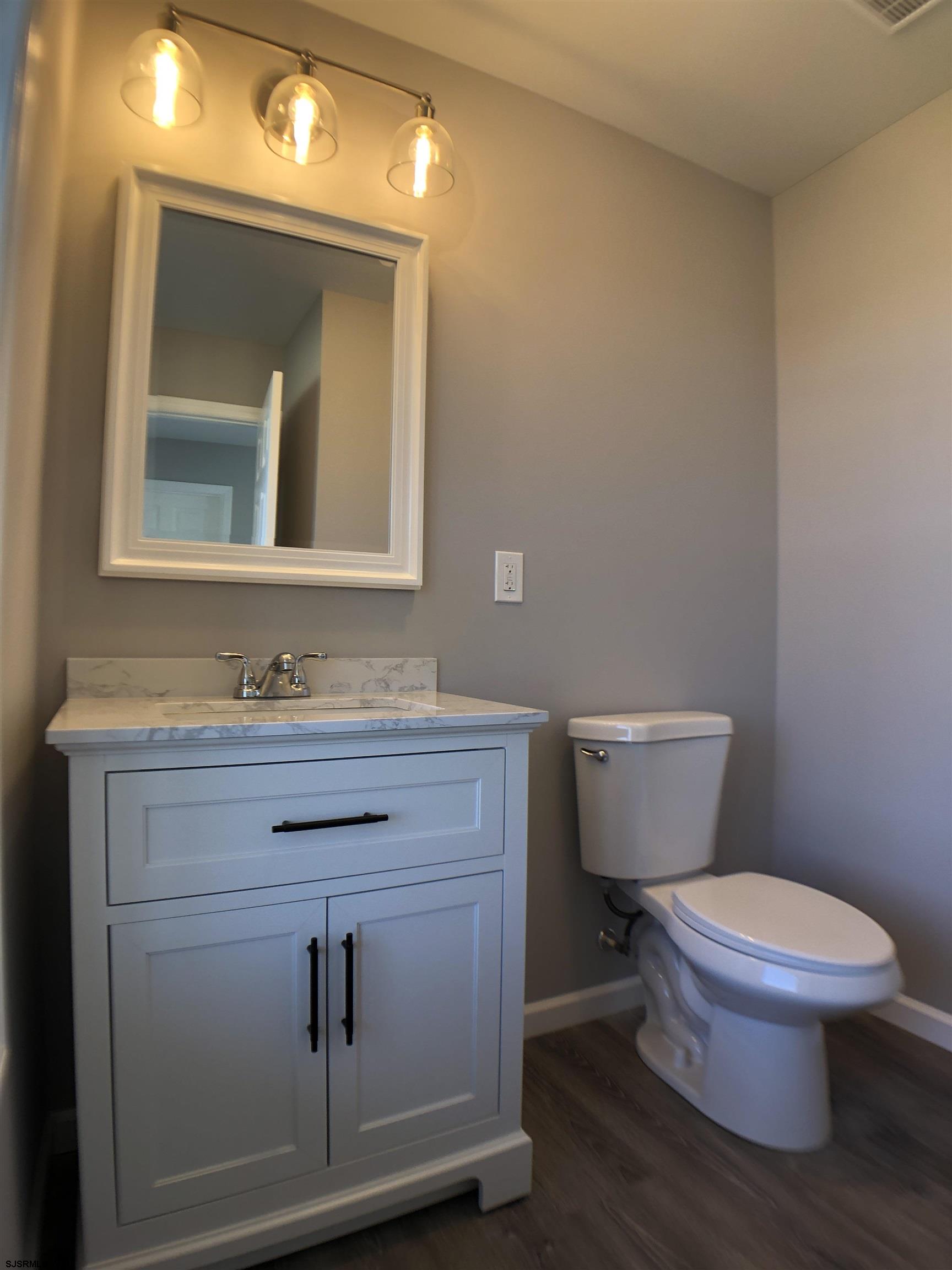 105 Wheat Road Vineland, NJ 08360 - Photo 13 of 30 a bathroom with a toilet sink vanity and mirror