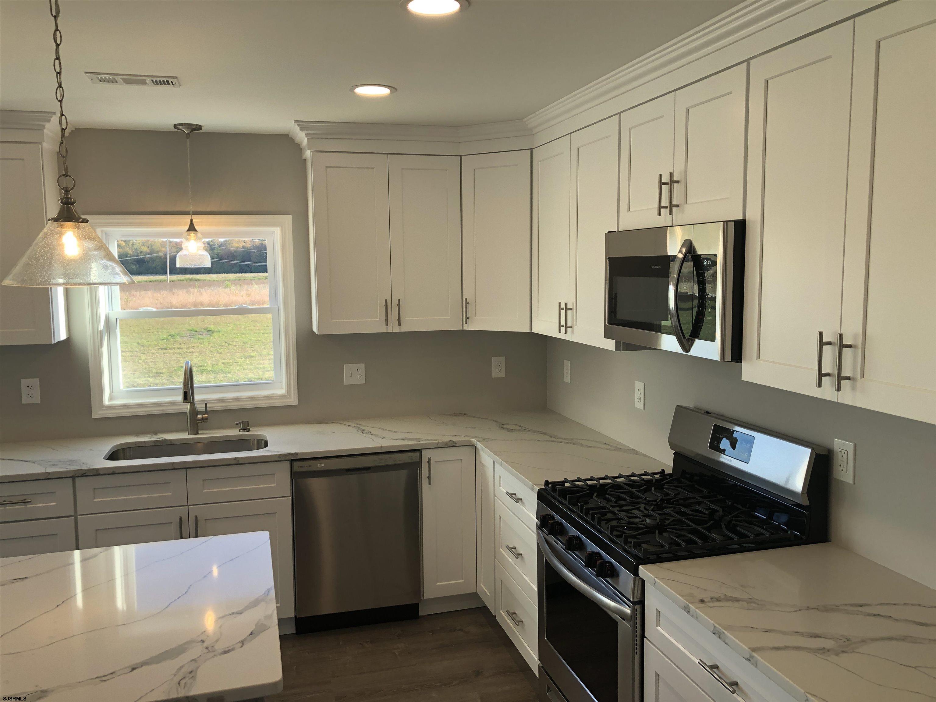 105 Wheat Road Vineland, NJ 08360 - Photo 8 of 30 a kitchen with granite countertop a sink a stove and cabinets