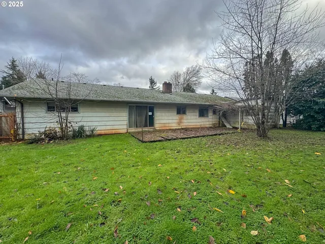 a front view of a house with a garden and lake view