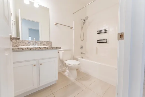 a bathroom with a granite countertop sink toilet a mirror and shower