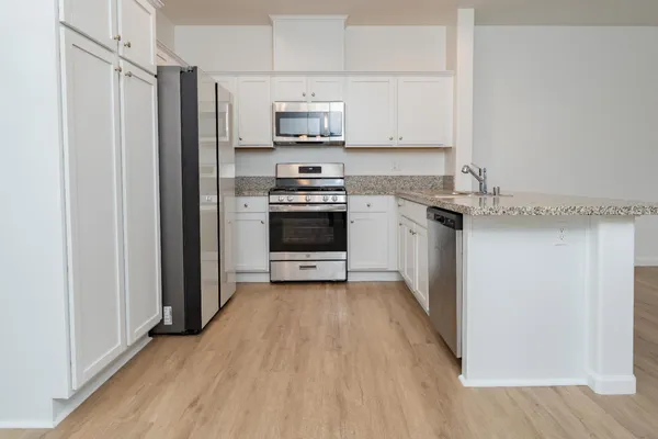 a kitchen with stainless steel appliances a refrigerator stove and microwave