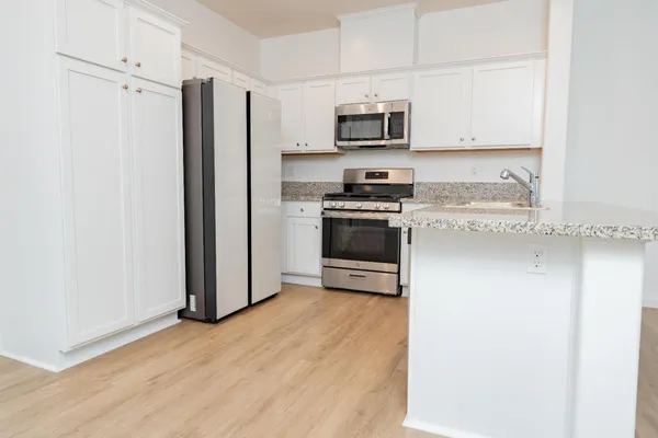 a kitchen with stainless steel appliances a stove a microwave and a refrigerator